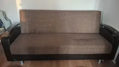 Canapea extensibilă din material textil în culoare maro, folosită, dar în stare bună. Poate fi utili